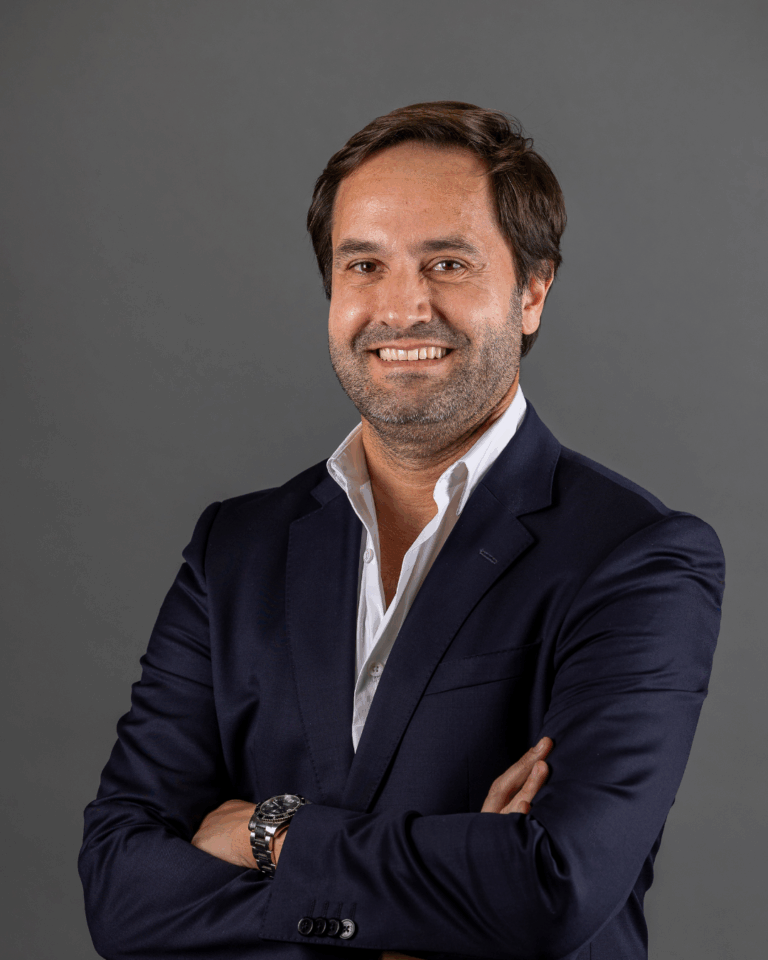 Homem de fato com braços cruzados.