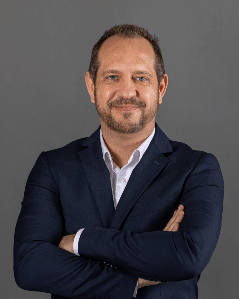 Homem de fato com braços cruzados.