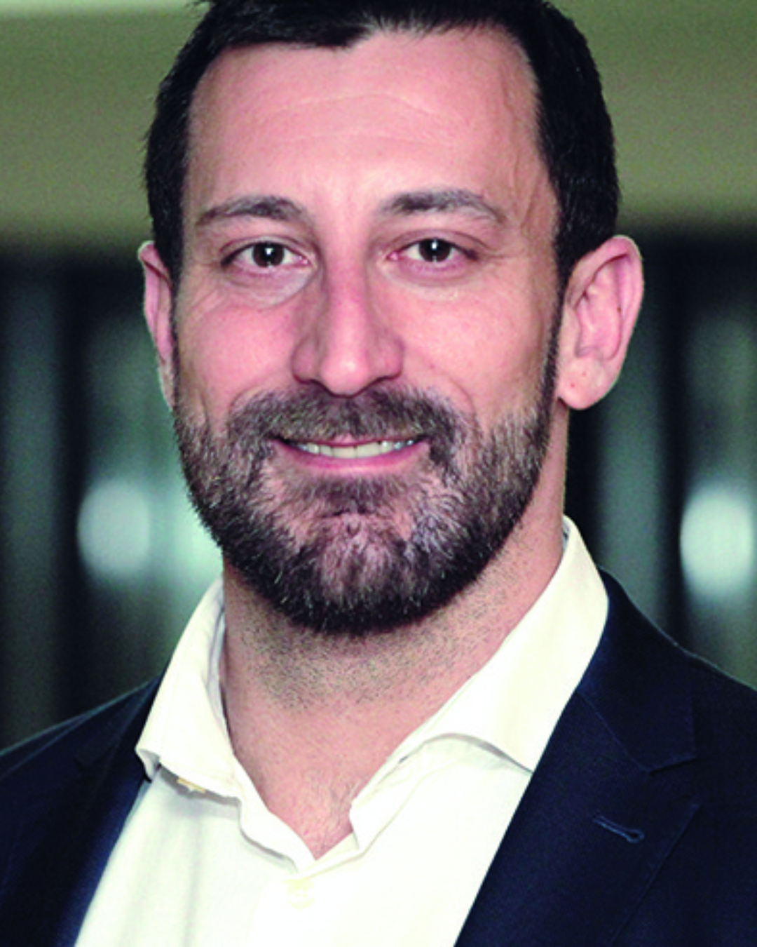 Homem em traje formal, ambiente interno.