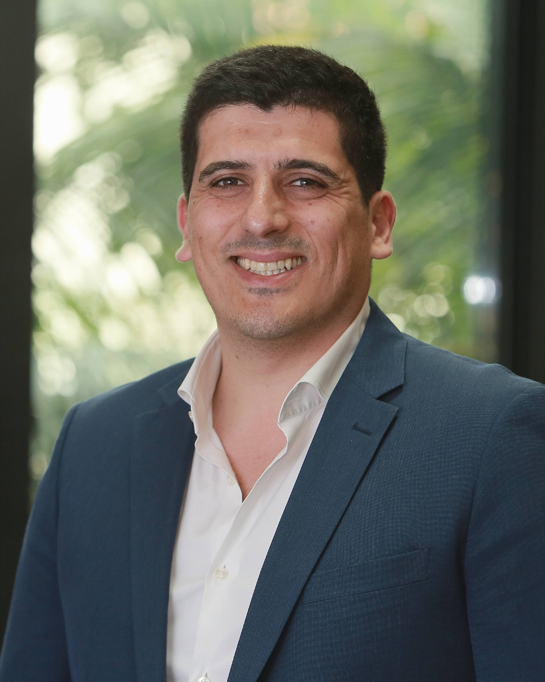 Homem em terno com fundo verde.