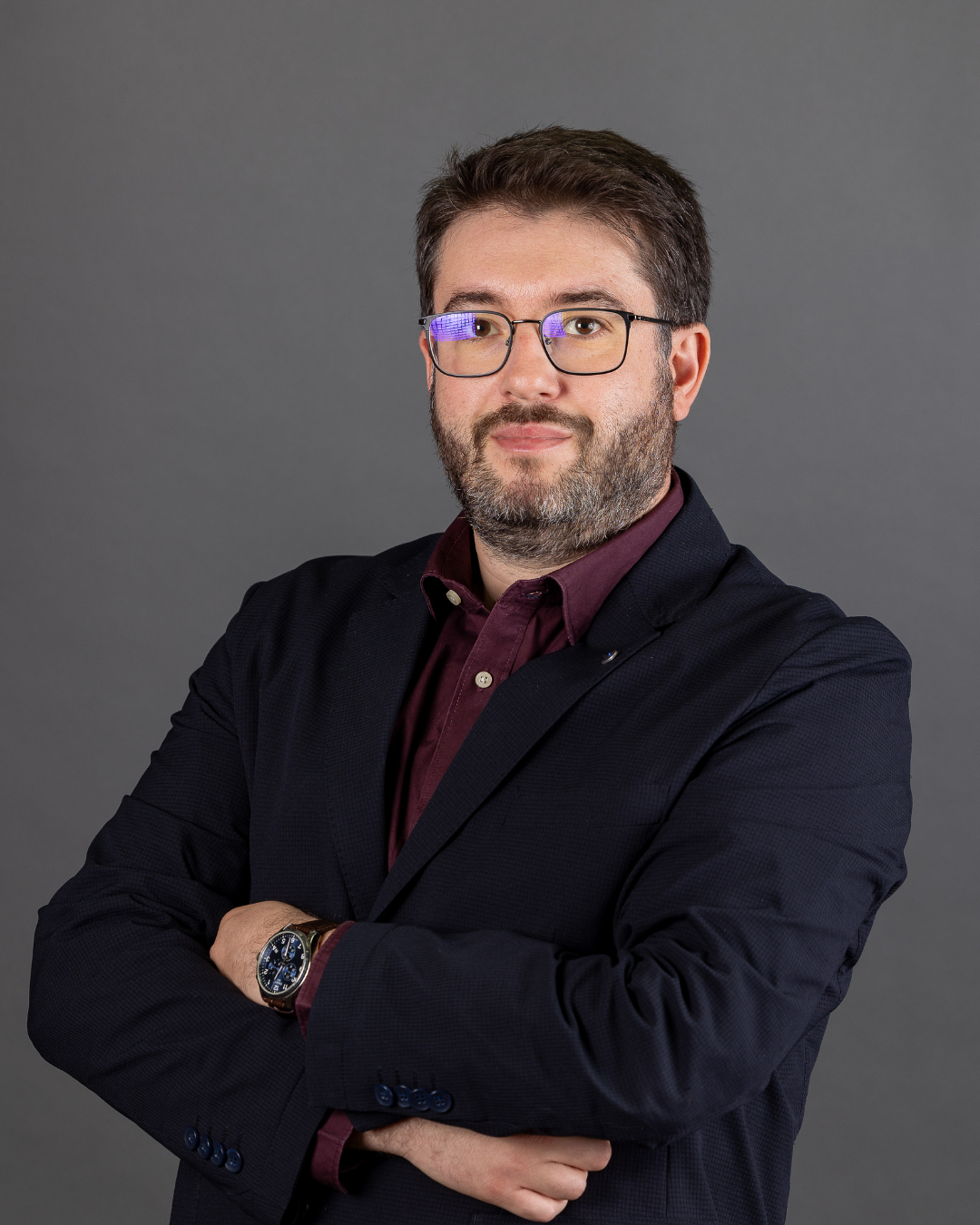 Homem de fato com braços cruzados.