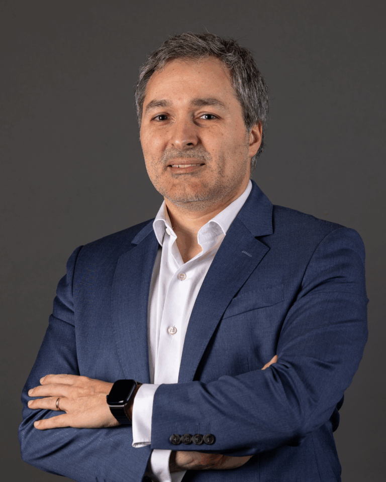 Homem de terno com braços cruzados.