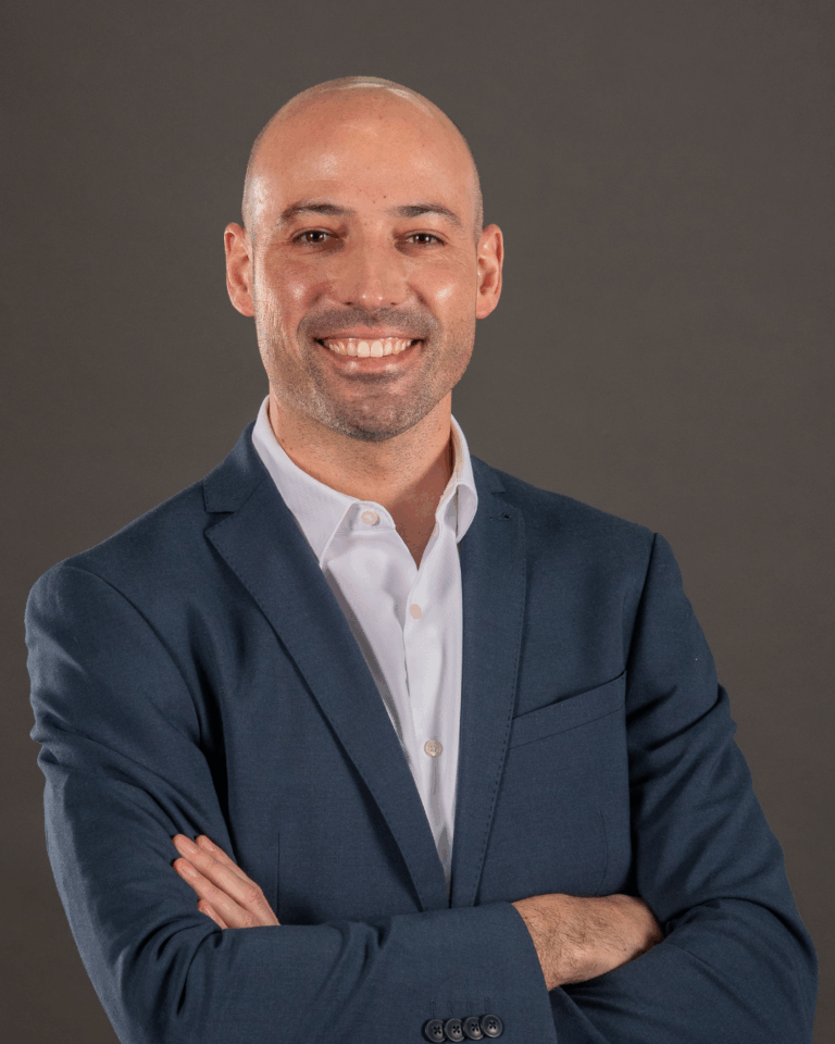 Homem de terno com braços cruzados.