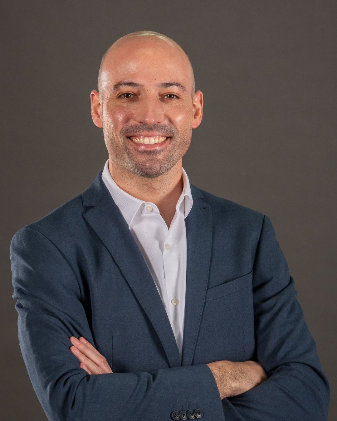 Homem de terno com braços cruzados.