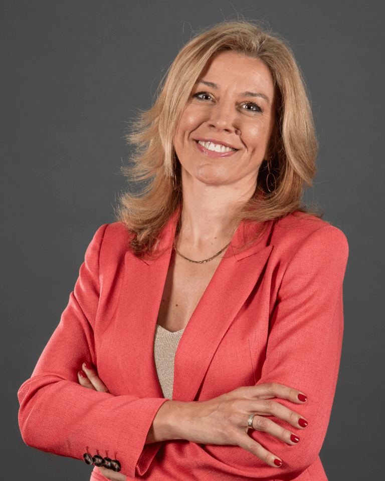 Mulher de blazer rosa posando confiante.