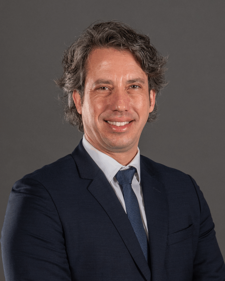 Homem de fato em fundo cinza.