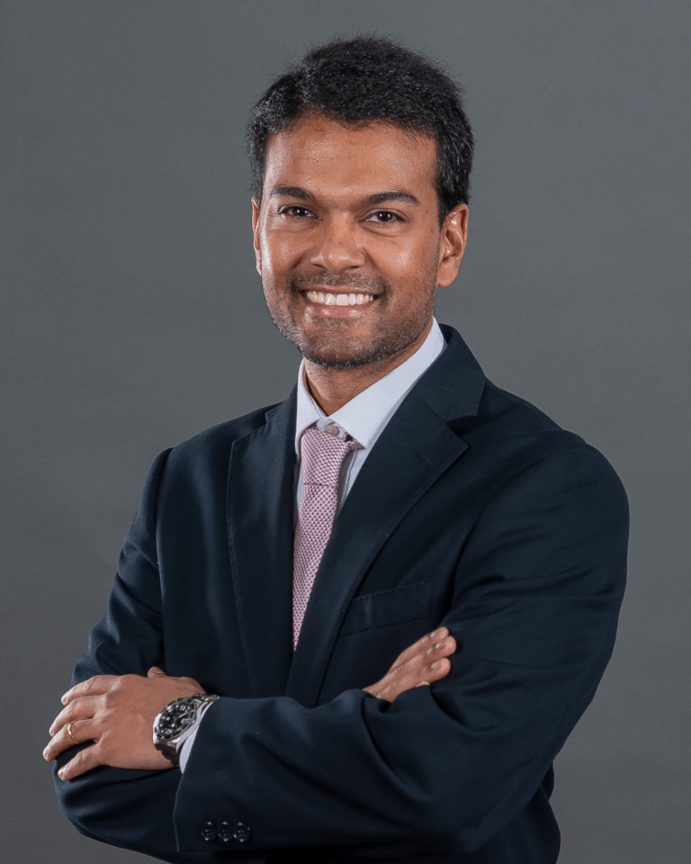 Homem de fato com braços cruzados.