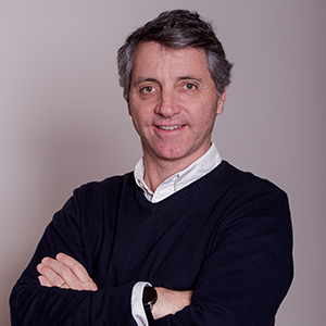 Homem com suéter e braços cruzados.