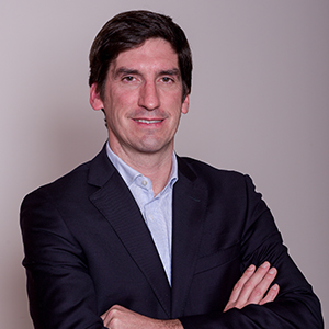 Homem de terno com braços cruzados.