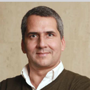 Homem com suéter e camisa branca.