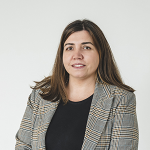 Mulher com blazer xadrez sorrindo.