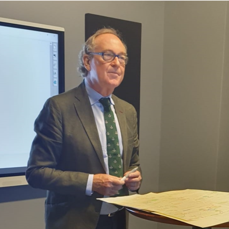 Homem apresentando em sala de reunião.